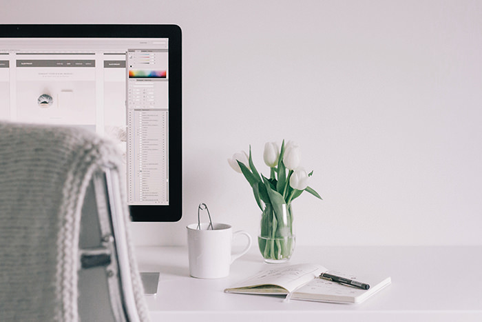 Apple monitor with a notepad next to it