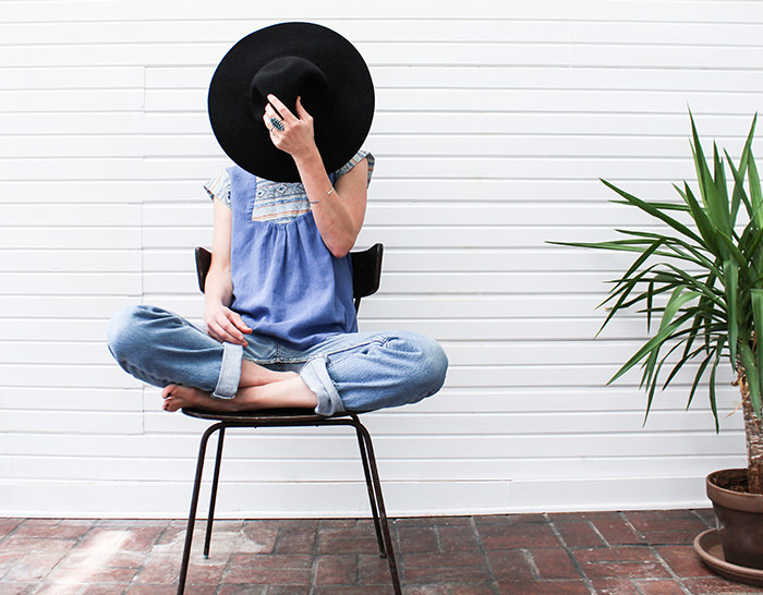 Girl hiding her face behind a hat